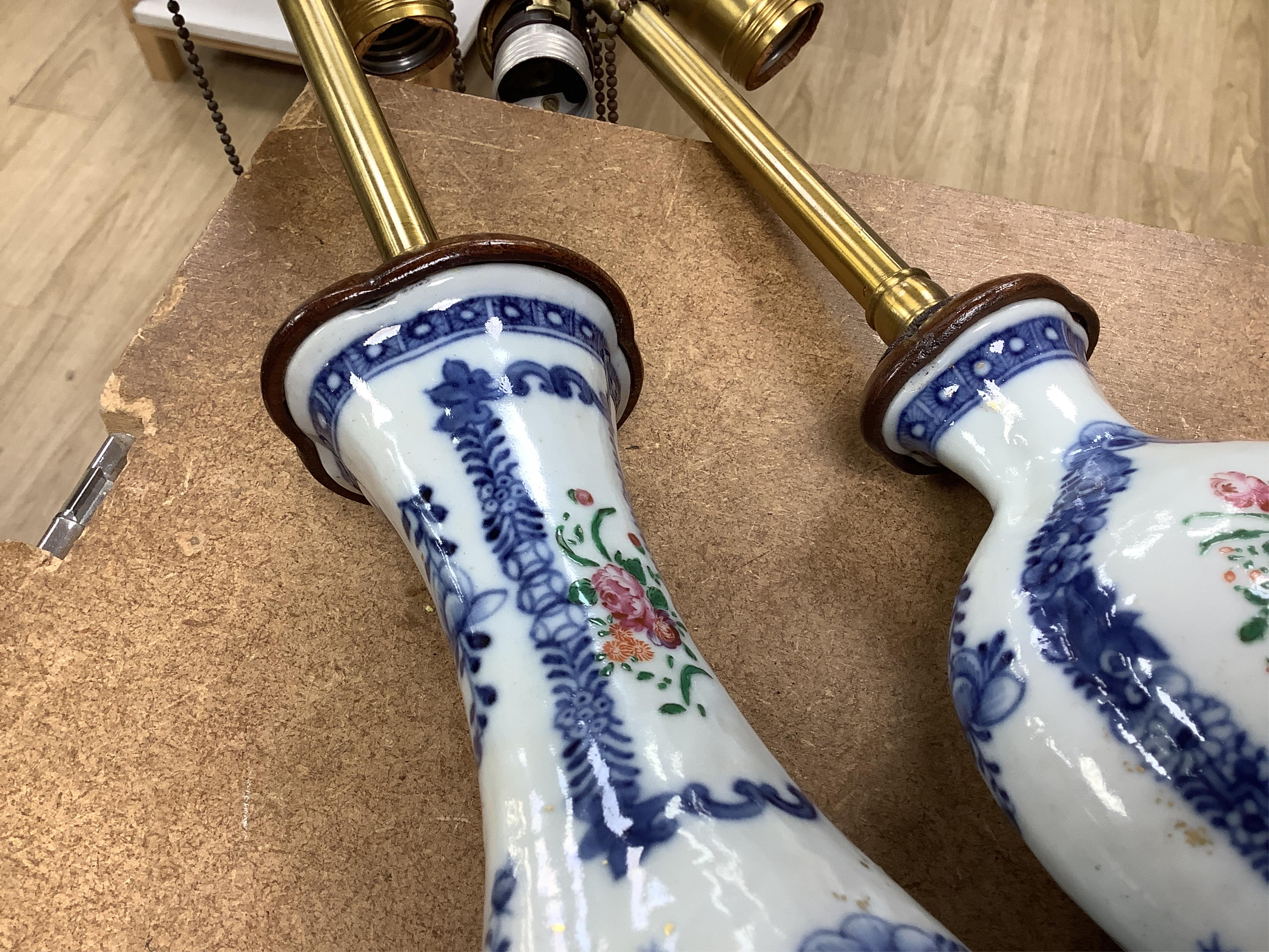 Two Chinese famille rose vases from a garniture, Qianlong period (1736-95), mounted as table lamps with shades, raised on shaped wood bases, overall 62cm high
